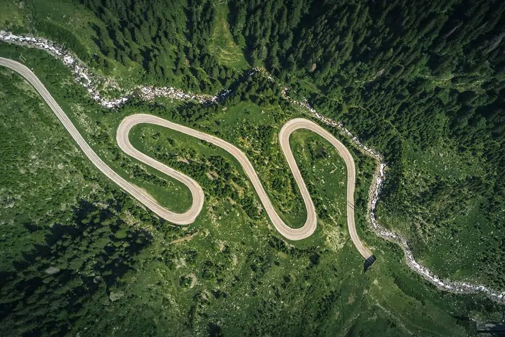 aerial photo of a winding road amongst greenery