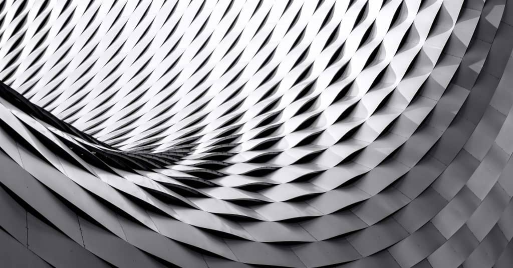 Silver geometric wall shaped like the inside of a cylinder.