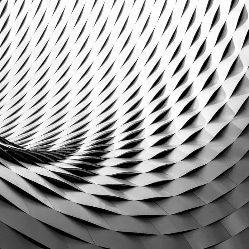 Silver geometric wall shaped like the inside of a cylinder.