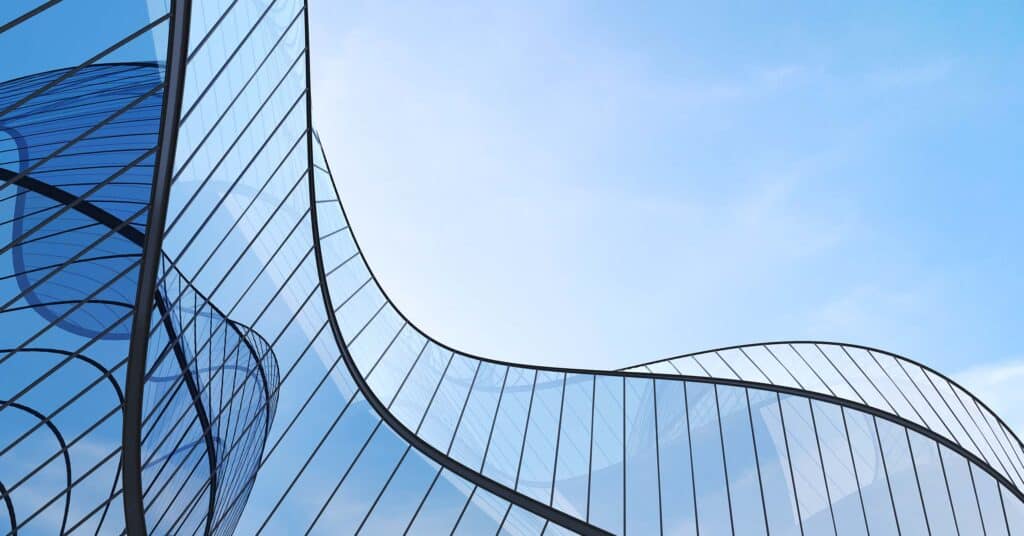 The wavy top of a glass building as viewed from the ground.