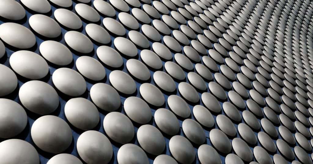 Geometric silver circles spreading outward across a surface.