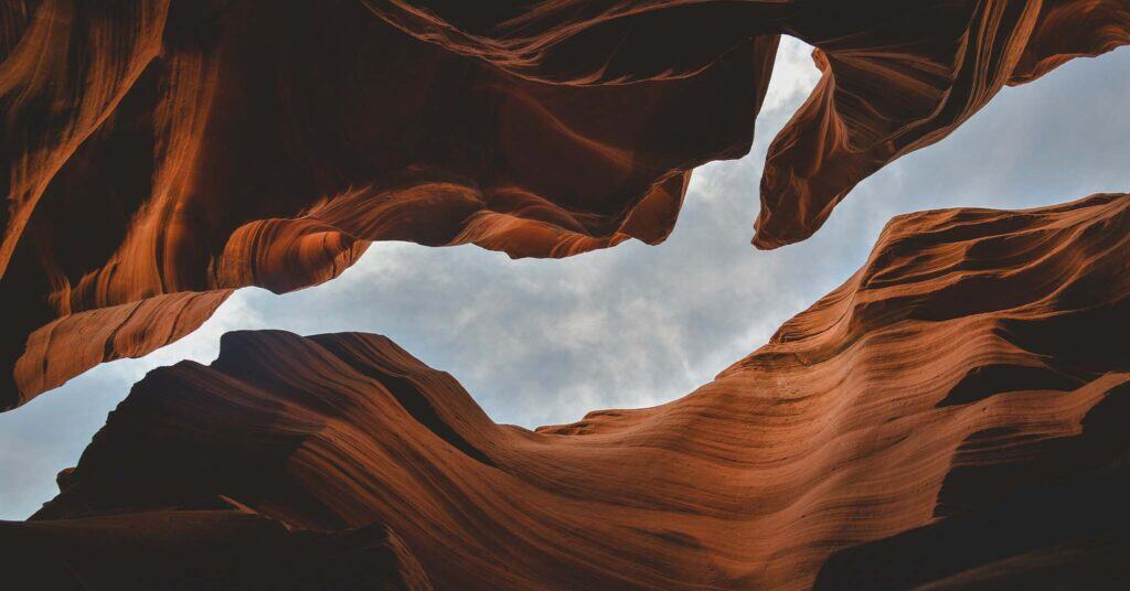 A photograph looking up through a canyon to a blue sky