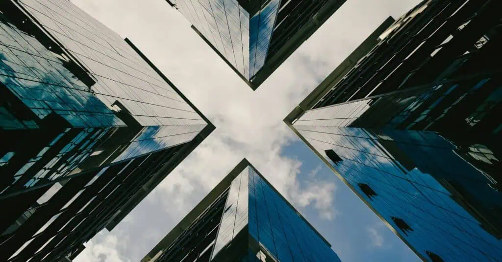 A view of buildings from the ground that make an "X" outline in the sky.